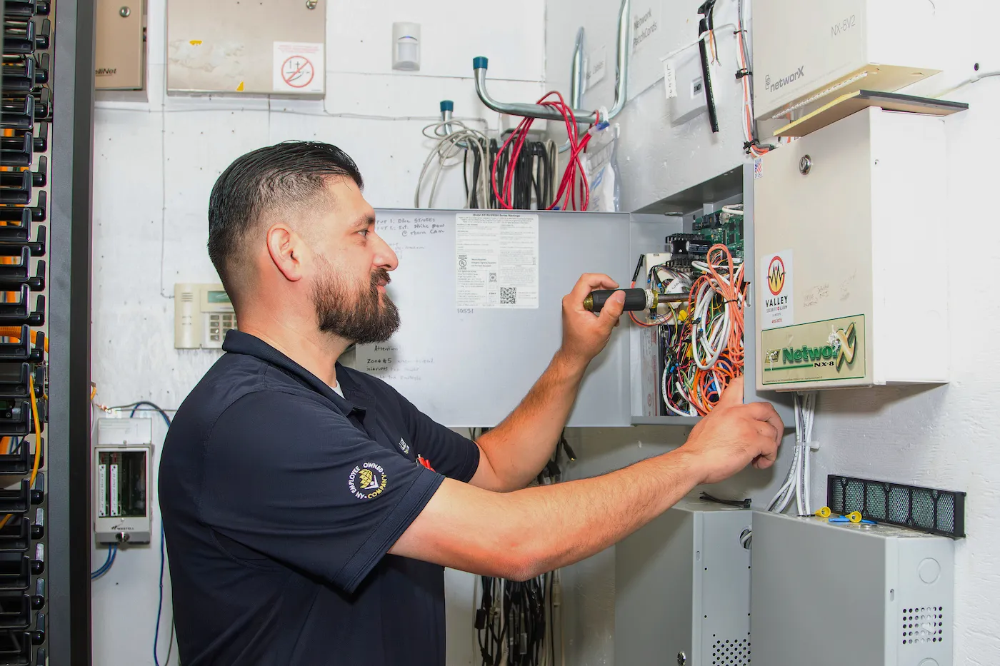 Technician installing a burglar alarm system for a business.