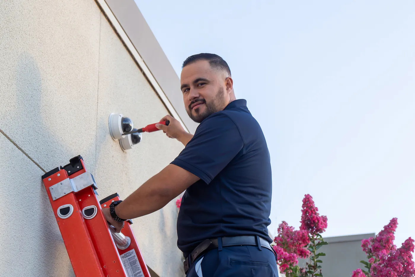 Technician installing exterior ai-driven security cameras